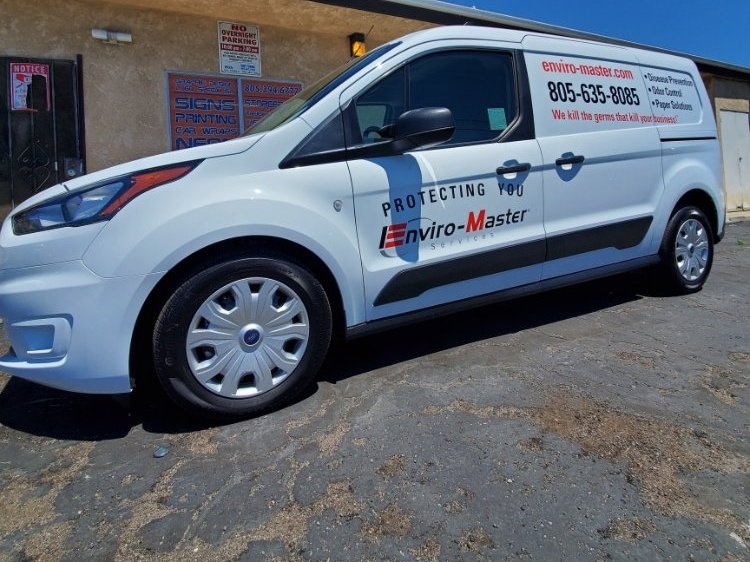 A small white cargo van with red and black company lettering, a phone number and a list of services on its side panels.