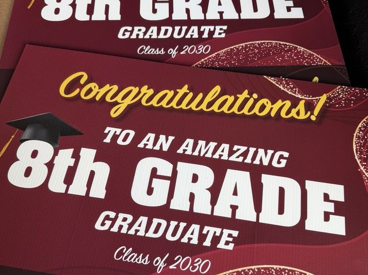 Two maroon corrugated yard signs printed "Congratulations! To an amazing 8th grade graduate, Class of 2030".